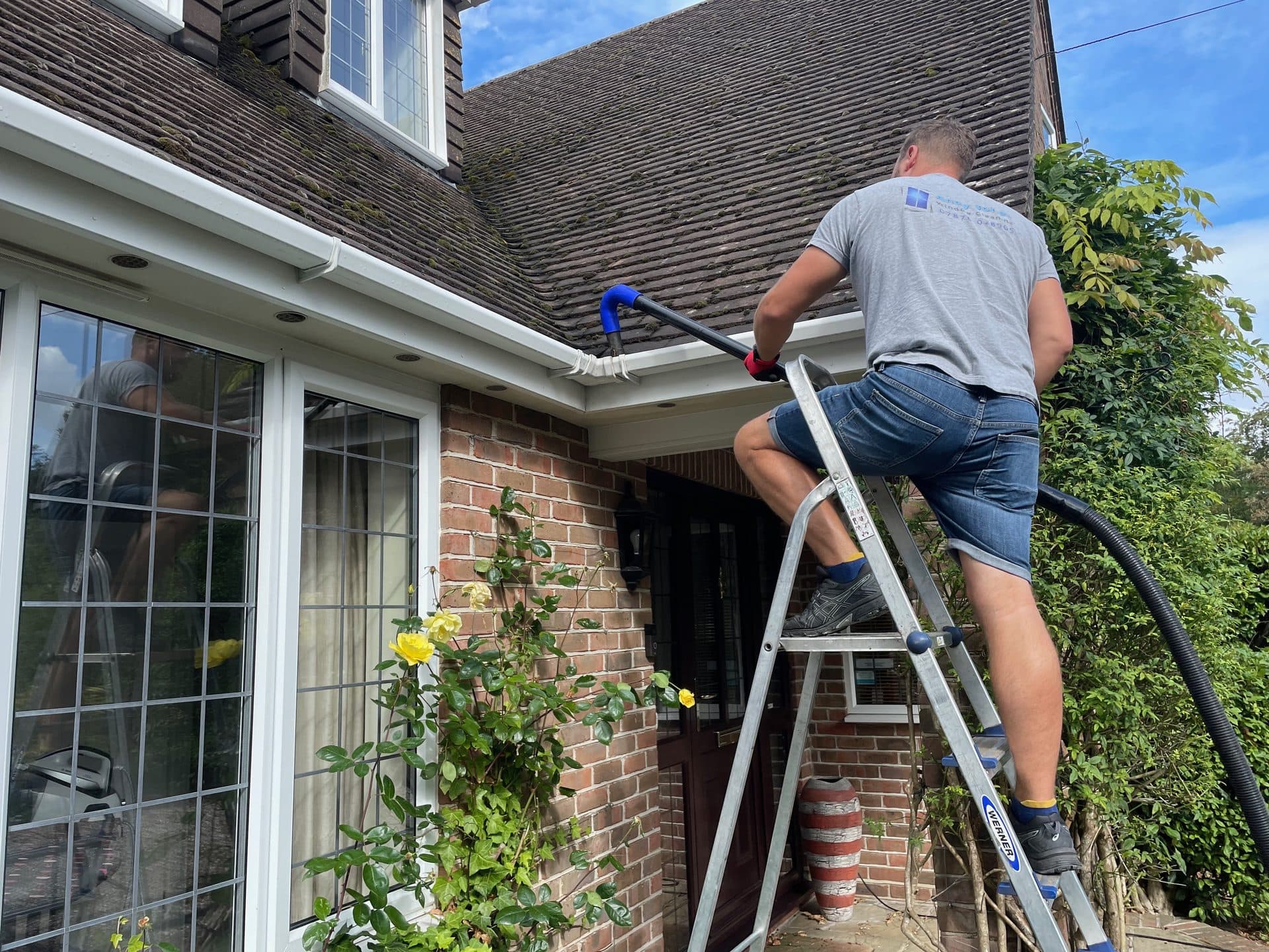 Moss and debris being cleared from a house gutter